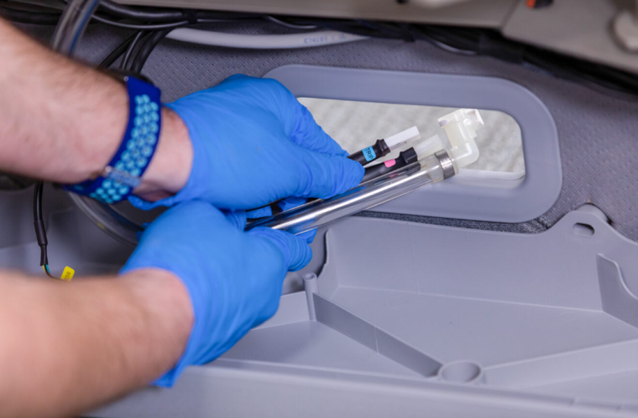Hands routing hoses and wires through a port cup on a FlexFit base.