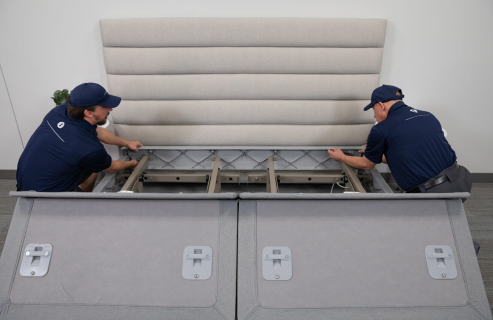 Two Sleep Number technicians installing a head rail onto a FlexFit base.