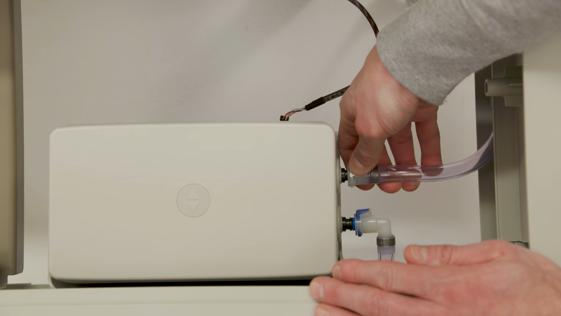 A person checking hose connections at the pump on a Firmness Control System.