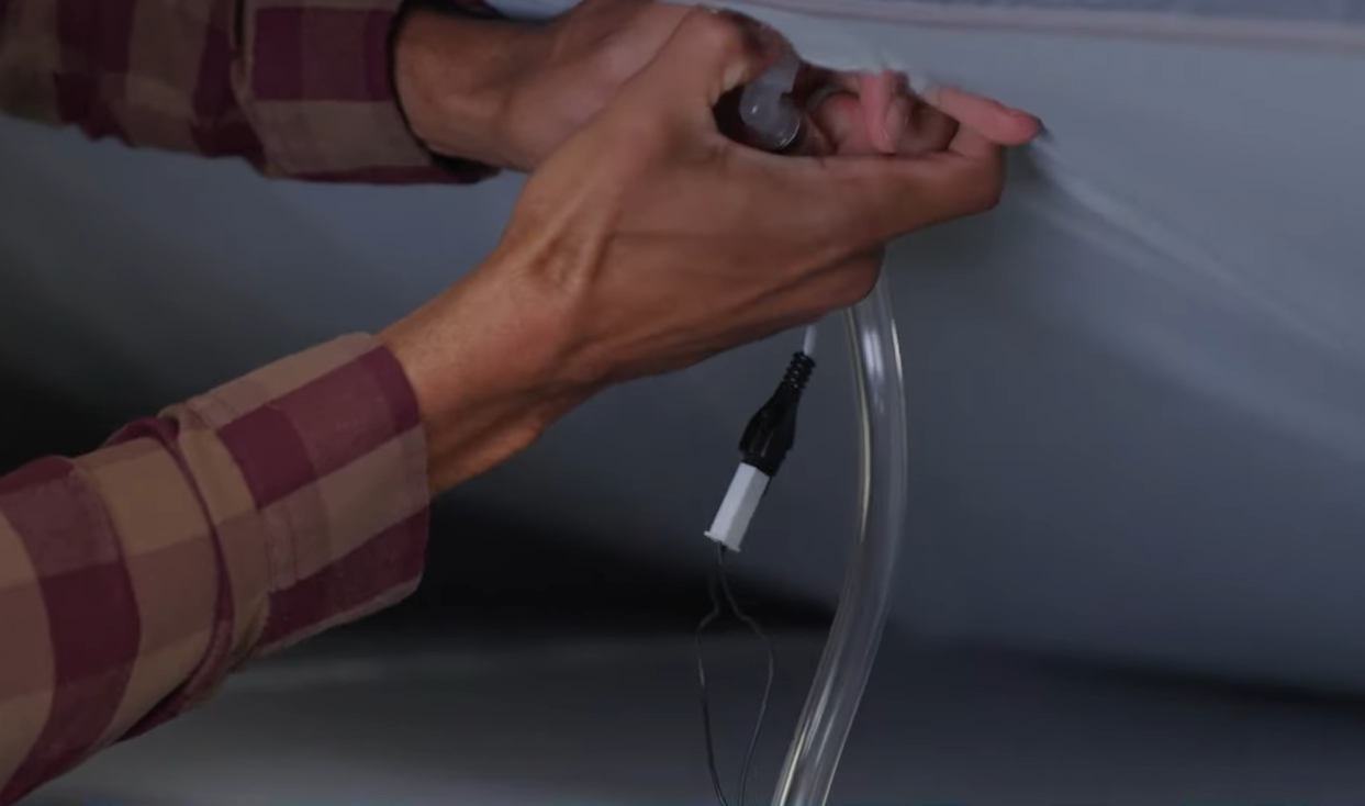 Hands disconnecting an air hose from the air chamber connector.