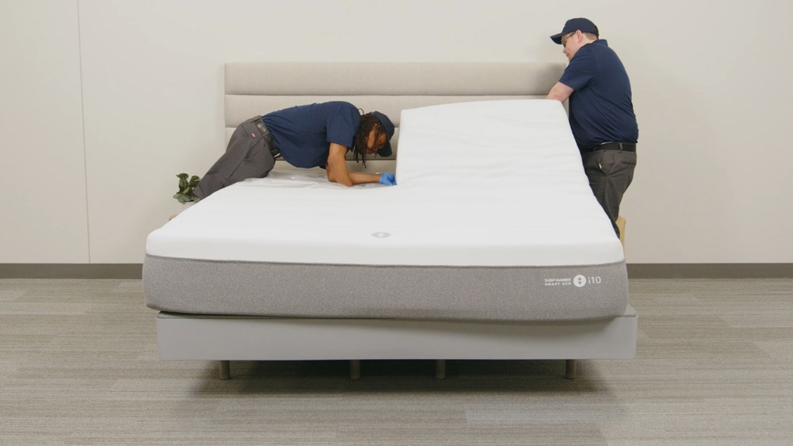 Raise the head of the bed, then unsnap the black straps at the head of the mattress.