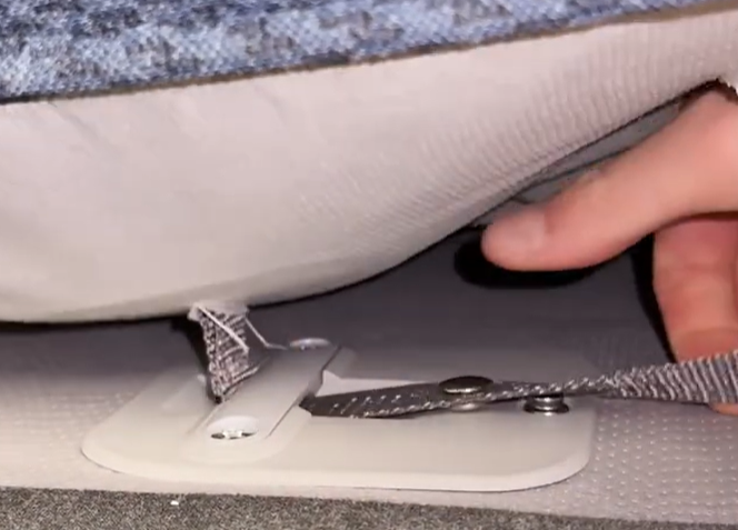 A zoomed in image of removing the mattress straps from the base.